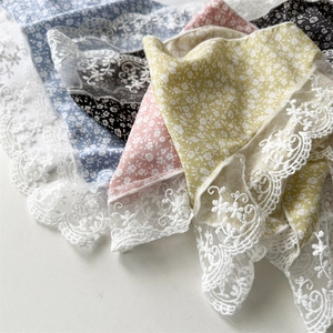 Close-up of floral silk scarves with lace trim in blue, black, pink, and yellow colors
