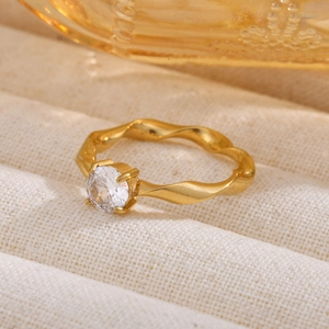 Detailed view of a gold Mobius ring featuring a sparkling round zircon stone inlay