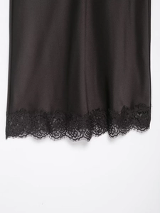 Détail du tissu satiné avec bordure en dentelle sur le haut à bretelles noir