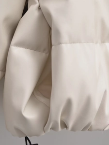 Detailed close-up of cream PU leather texture and stitching on winter padded jacket