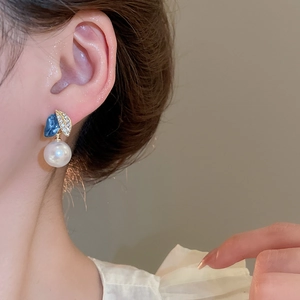 Detailansicht französischer Vintage-Ohrringe mit weißer Perle und blauen Blumen-Elementen