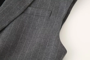 Détail du tissu gris à rayures fines montrant la poche de gilet et la couture d'épaule