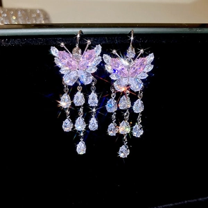 Gros plan de boucles d'oreilles papillon avec strass roses et cristaux scintillants