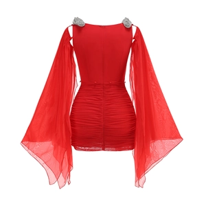 Détail des nœuds en strass argentés et manches en mousseline sur robe rouge plissée