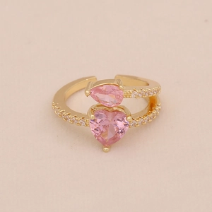 Gros plan de pierres roses en forme de cœur et de poire sur bague dorée