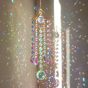 Macro shot of geometric crystal suncatcher reflecting vibrant rainbows on the wall