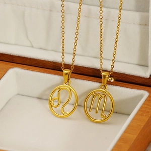 Golden zodiac necklaces with Leo and Scorpio symbols in a wooden jewelry box display
