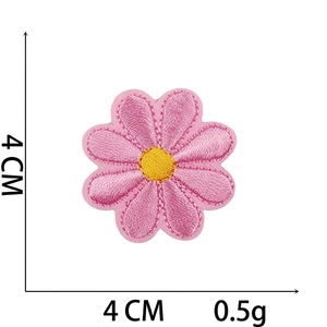 Detail of pink flower embroidery patch with yellow center and stitching 4cm x 4cm