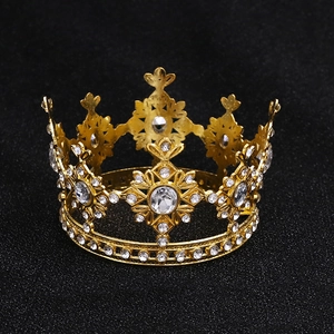 Close-up of golden crown decoration with sparkling transparent crystals on a dark surface