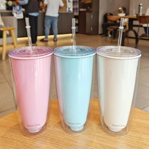 Detailed view of 750ml pink, blue, and white double-layer plastic straw cups on a table