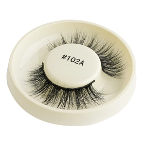 Detail view of thick black false eyelashes model #102A on a white circular tray