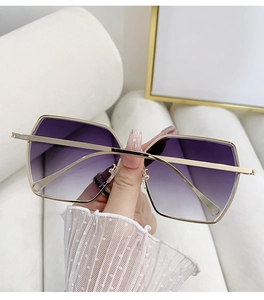 Detailed macro view of purple gradient lenses and slim golden metal frame sunglasses