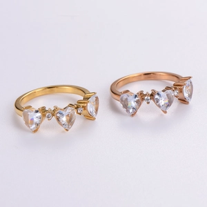 Polished gold and rose gold stainless steel rings with three heart-shaped cubic zirconia