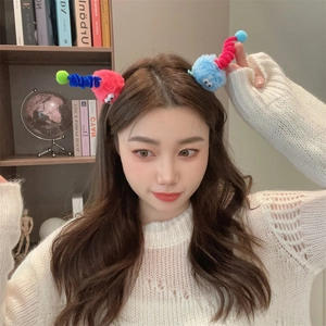 Detail of quirky plush monster hair clips with colorful furry tentacles and eye elements