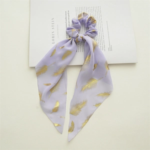 Detail of lavender chiffon scrunchie with golden feather print and long ribbon tails