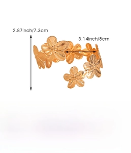 Detail of golden flower hollow arm cuff with 2.87-inch size dimensions on white background