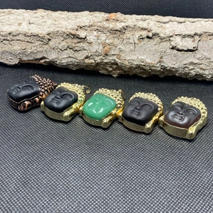 Macro shot of Buddha head pendants in crystal and glass with gold-toned metal edging