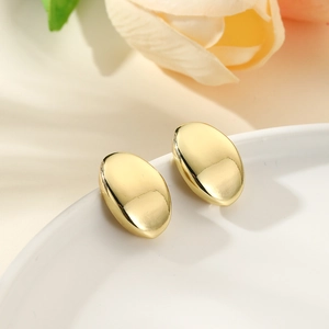 Minimalist oval geometric stud earrings in 18k gold plated finish on white ceramic