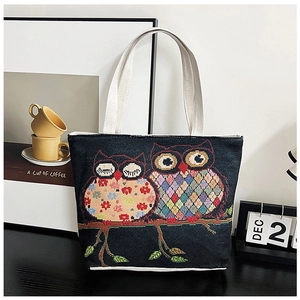 Detailed embroidery of colorful geometric owls on a sturdy canvas tote bag