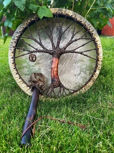 Detail of Shaman drum back with Tree of Life woven totem on green grass setting