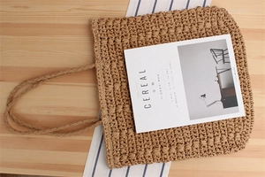 Detail of handwoven paper rope tote bag with rustic texture and braided handles