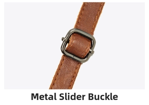 Detail view of brown leather bag strap with adjustable gunmetal buckle and yellow stitching