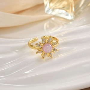 Adjustable golden sunflower ring with pink center stone and zircon petals on porcelain tray