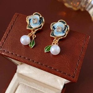 Detail of flower earrings with blue enamel camellia, crystals and white pearl drops