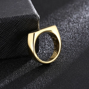 Primo piano di un anello a sigillo in oro lucido appoggiato a un portagioie nero