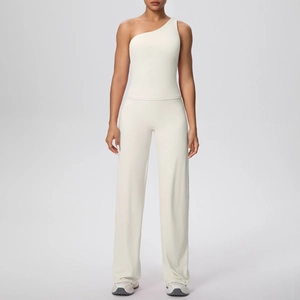 Détail d'un haut de sport à une épaule blanc crème et d'un pantalon de yoga à jambes larges