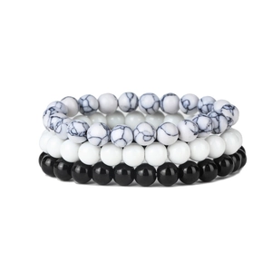 Close-up of a 4-piece elastic beaded bracelet set with marble texture and black-white beads
