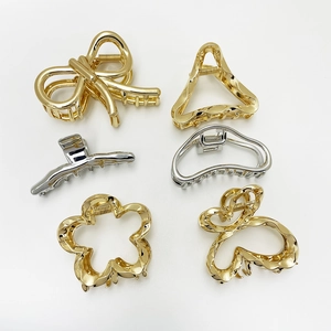 Detailed flat lay of assorted minimalist gold and silver alloy claw clips in varied shapes