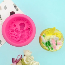 Detail view of round silicone mold with flower fairy pattern and finished pink soap craft