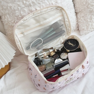 Pink quilted makeup bag detail showing large capacity main compartment and mesh pocket