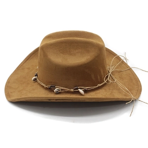 Detail of western cowboy hat with suede texture, seashell accents and braided rope band