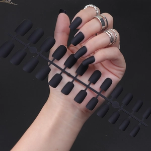 Detail shot of long square matte black fake nails on a hand with a professional runner frame