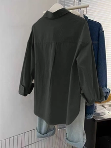 Détail du dos d'une chemise noire à manches longues avec empiècement et pli d'aisance