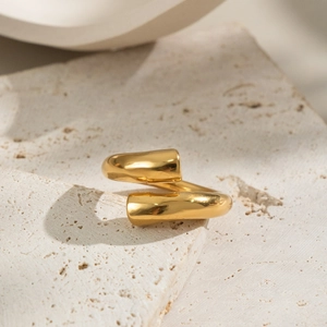 Minimalist gold spiral open ring with smooth metallic finish on natural stone