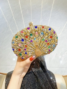 Close-up of golden peacock evening clutch bag with sparkling colorful rhinestones