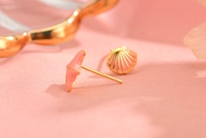 Macro detail of asymmetric pink enamel shell and fishtail earrings with S925 silver hallmark