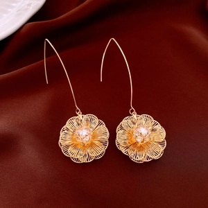 Macro des boucles d'oreilles pendantes fleurs plaquées or 18K sur satin sombre
