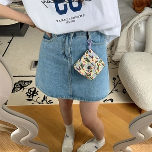 Floral mini pouch with purple clip shown attached to denim skirt for portable use