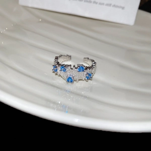 Detailed view of irregular textured silver ring with five sparkling blue zircons