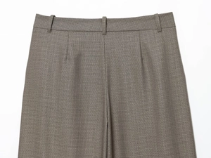 Detail of high-waisted dark grey trousers with belt loops and fine blend fabric texture