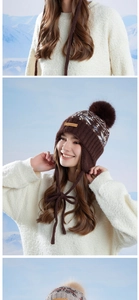 Detail of winter knitted trapper hat with pom-pom and leather label against snowy peaks