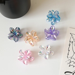 Detail of six colorful floral hair claws with pearlescent finish on white background