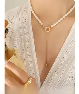 Elegant freshwater pearl necklace and gold ring with zircon on a lace white shirt