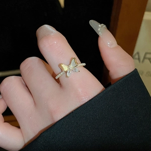 Detailed view of an elegant gold plated butterfly ring with pearls on a model finger