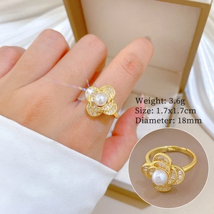 Detail of gold four-leaf clover ring with white pearl and micro-pave crystals on model