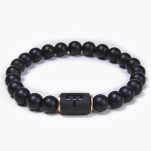 Close-up of matte black onyx bead bracelet with rose gold spacers and Aries zodiac sign